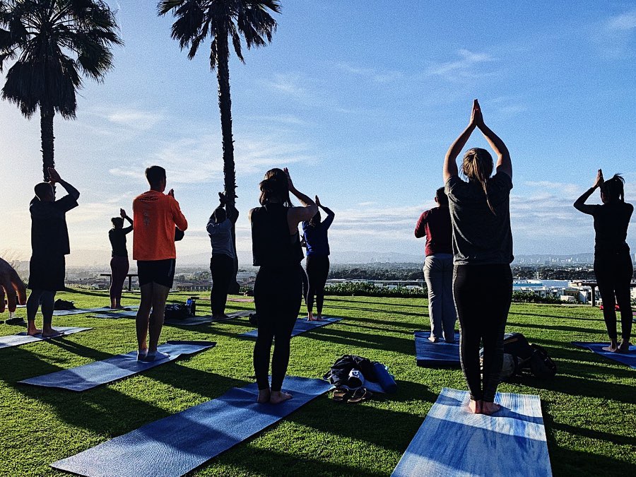 Students in yoga poses outside on the bluff at LMU